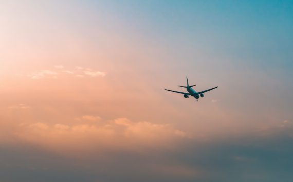 Aircraft flying over clouds, aviation sunset background, essential transport for business and travel